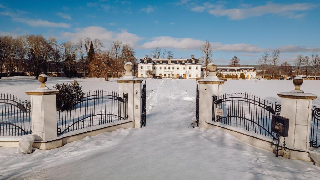 een poort naar een huis in de sneeuw bij Pałac Pakoszów Schlosshotel Wernersdorf in Jelenia Góra