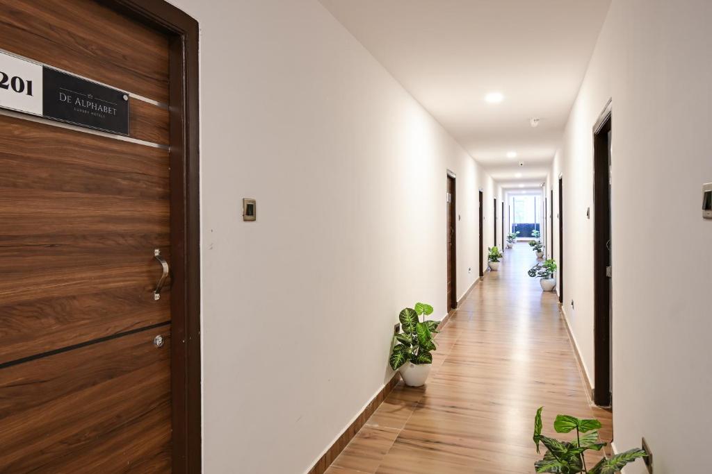 un couloir avec des plantes en pot et une porte dans l'établissement Super Townhouse De Alphabet Karmanghat, à Hyderabad