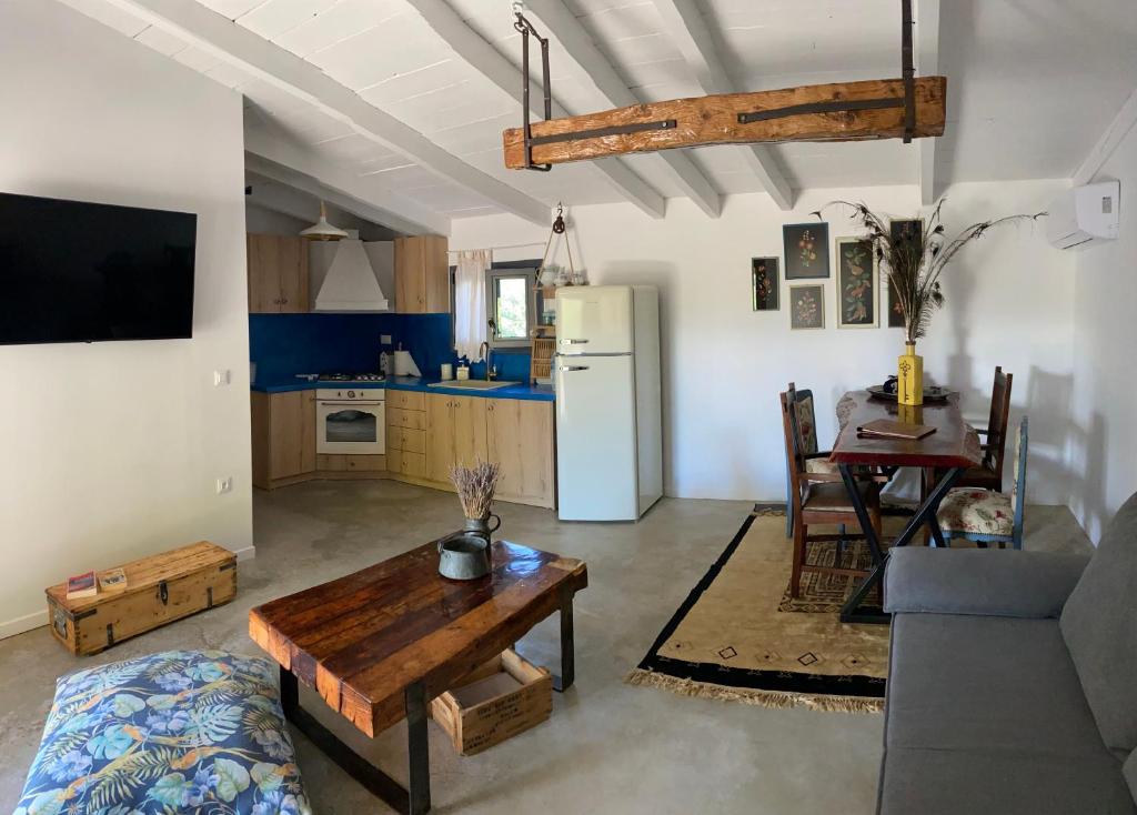 a living room with a couch and a table and a kitchen at Lavender farm house in Nafpaktos