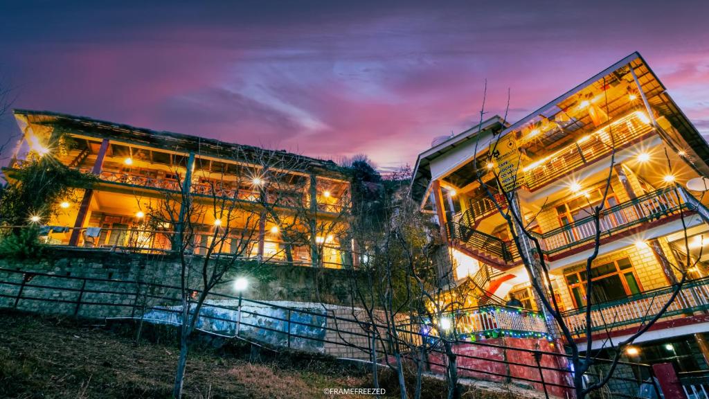 a building at night with lights on at Timberwolves in Manāli