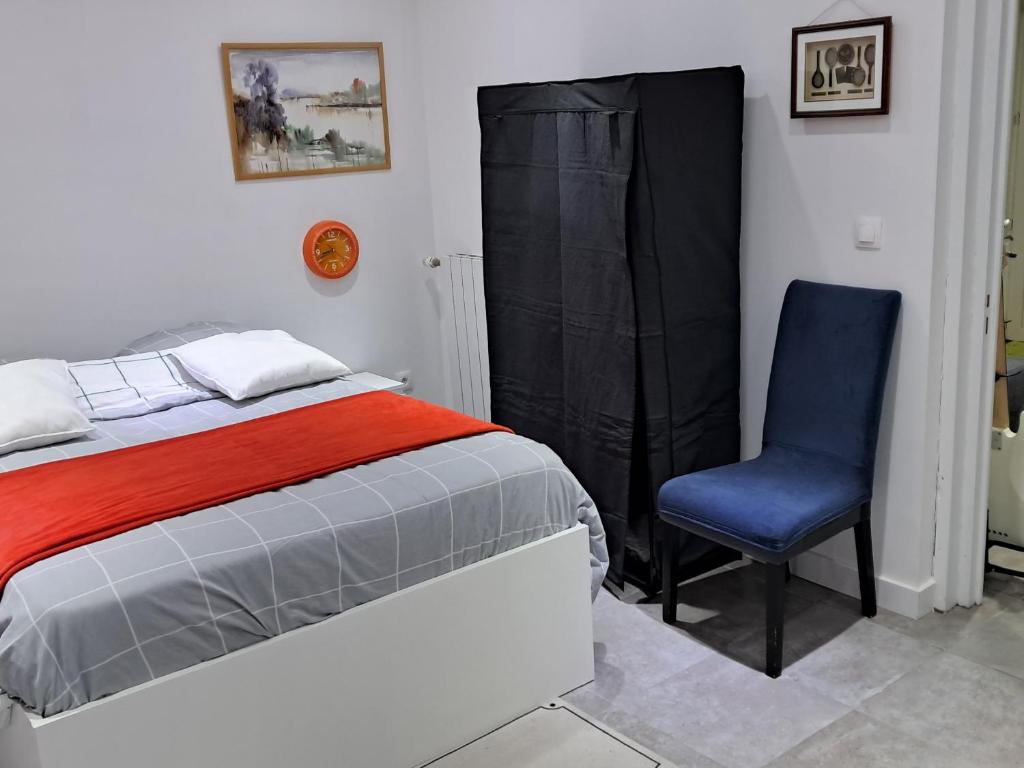 een slaapkamer met een bed en een blauwe stoel bij Appartement de vacances in Illkirch-Graffenstaden