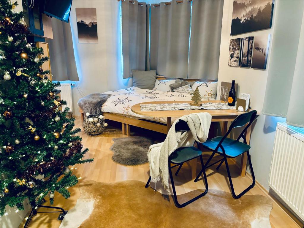 a room with a christmas tree and a table and chairs at Apartmán Pec 322 in Pec pod Sněžkou