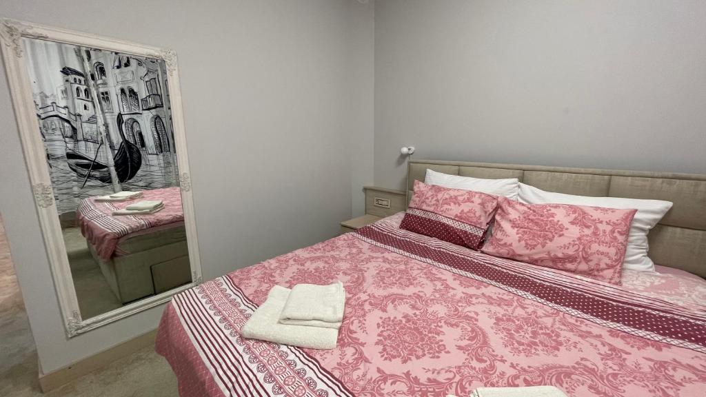 - une chambre avec un lit rose, des oreillers et un miroir dans l'établissement SMART, à Niš