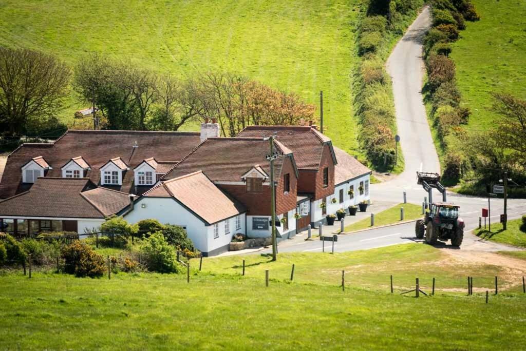 uma vista aérea de uma casa com um tractor à sua frente em The Chequers Inn em Rookley