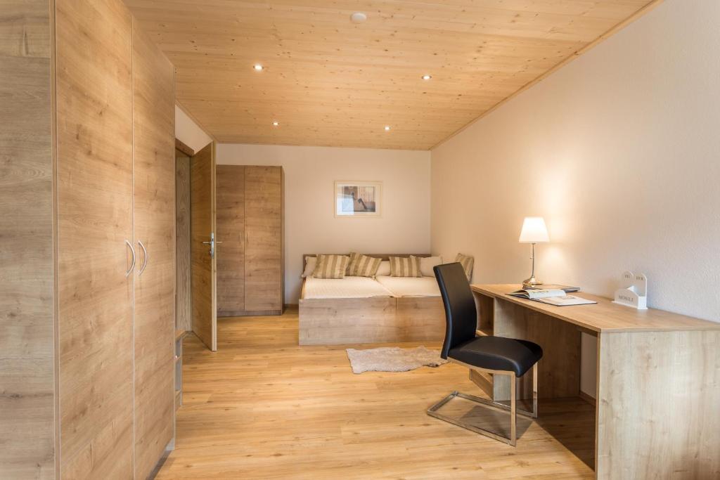 ein Heimbüro mit einem Schreibtisch und einem Schlafzimmer in der Unterkunft Appartements Lilly Rose in Zell am Ziller