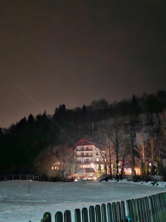 um edifício à noite com neve no chão em Rare Forest Retreat em Bran