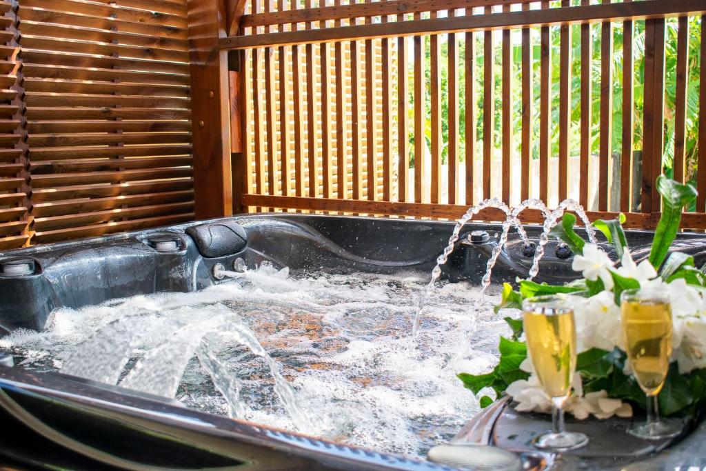 a fountain in a sink with two drinks in it at Villa Le Colonial Zen - T4 à 5 mn Aéroport in Sainte-Marie