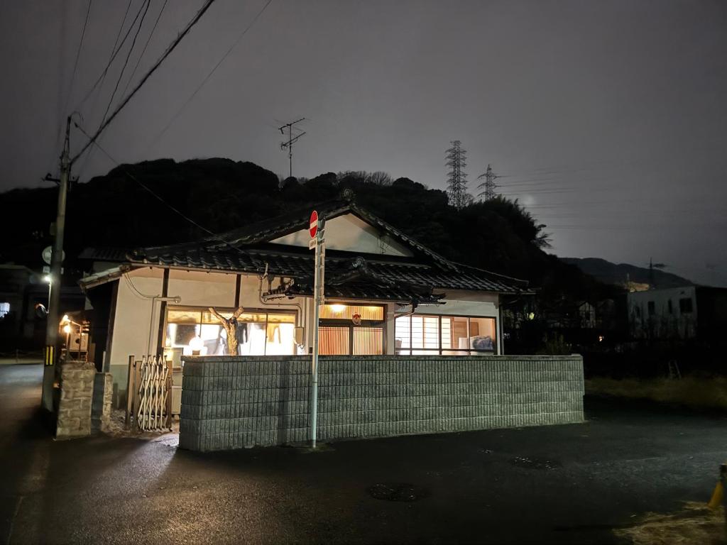 ein kleines Haus mit einer Flagge davor in der Unterkunft Wholeearth Ryokan Hiroshima in Hiroshima