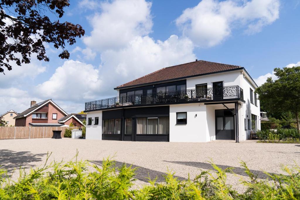 een wit huis met een balkon op een oprit bij Boutique Hotel Villa Elise in Winterswijk