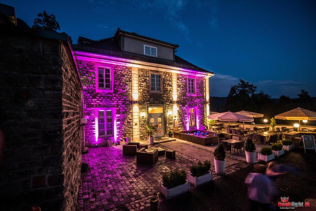 un edificio con luces moradas en él por la noche en Berghotel Eisenach, en Eisenach