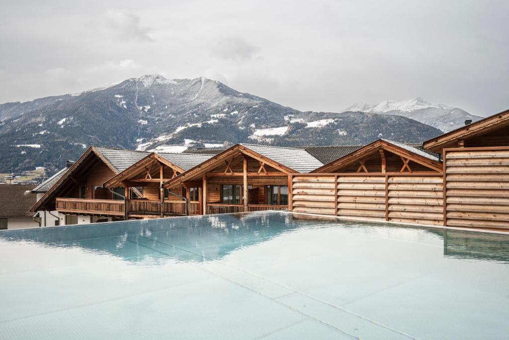 a house with a swimming pool in front of a mountain at Apartment Lodge Gasserhof in Bressanone