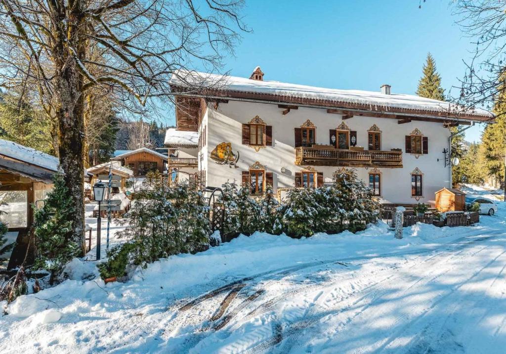 una casa con la neve per terra davanti di Die Bäckeralm a Bayrischzell