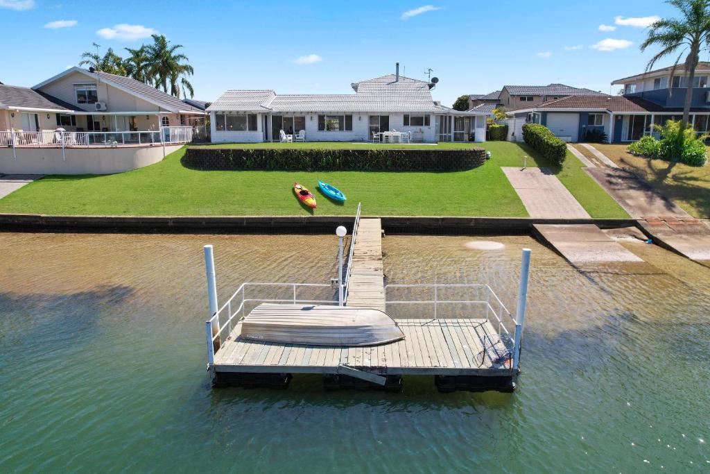 łódź siedząca na wodzie przed domem w obiekcie Deja Bleu - great family home with jetty w mieście Port Macquarie