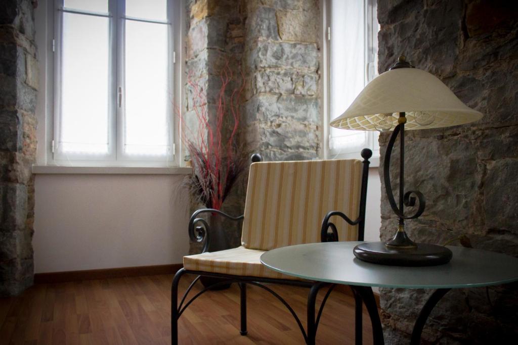 einen Tisch mit einer Lampe, einem Stuhl und einem Tisch mit einer Lampe in der Unterkunft Residence Theresia- Tailor Made Stay in Triest