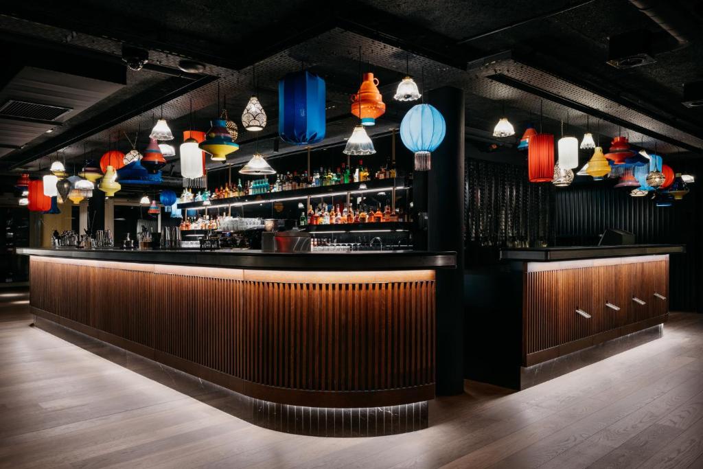 a bar with colorful lights on the wall at Ruby Claire Hotel Geneva in Geneva