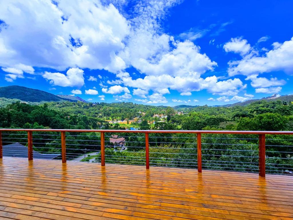 una terrazza in legno con vista sulle montagne di Chalés Mirante Monte Verde a Monte Verde