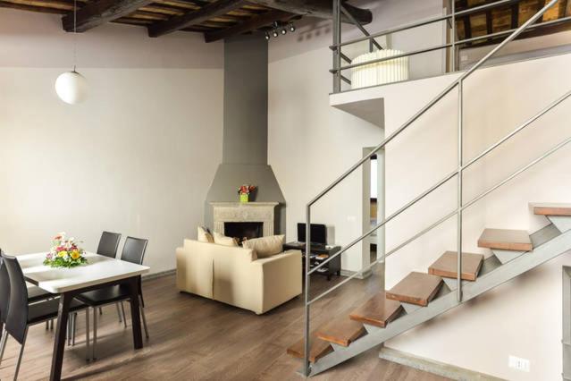 a living room with a staircase and a table and a couch at Navona Rubens Lodge in Rome