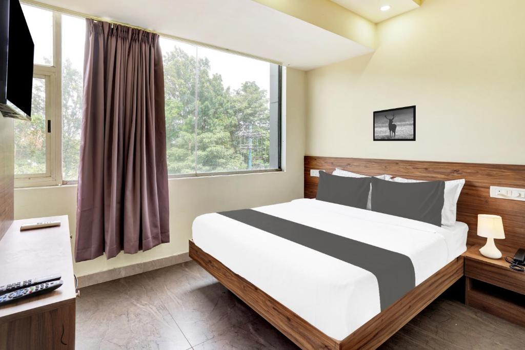 een slaapkamer met een groot bed en een raam bij Hotel O GAYATHRI METRO DELUXE in Bangalore