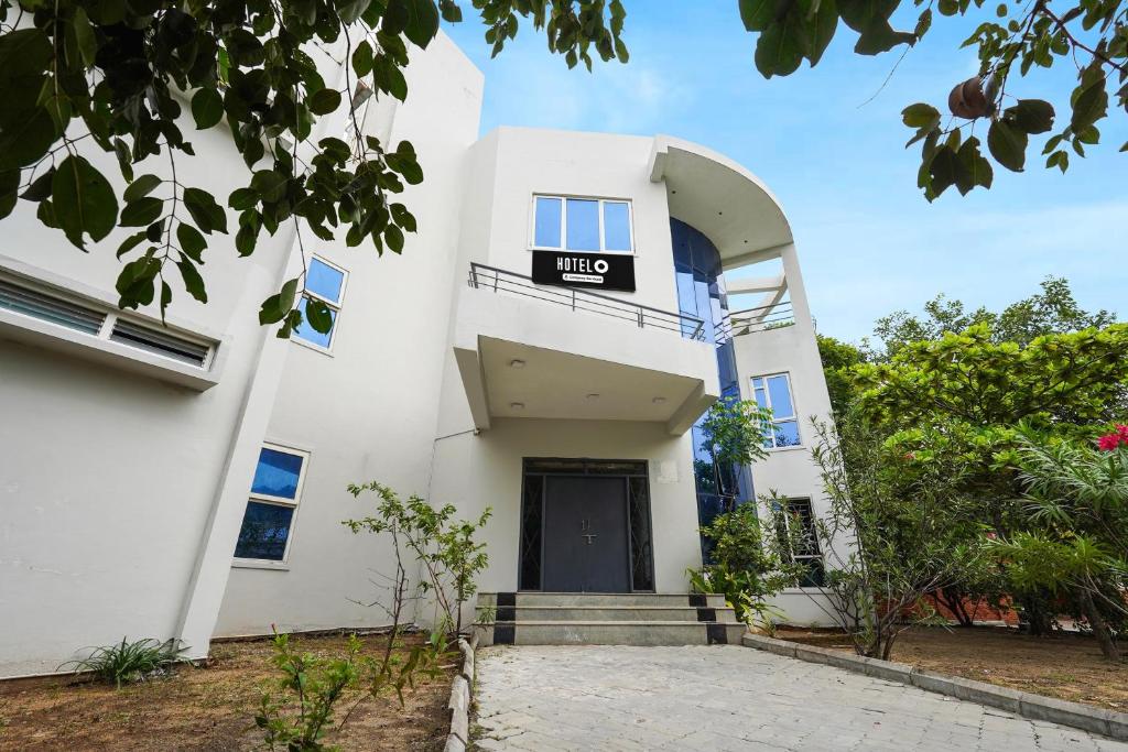 a white building with a sign that reads hdb at Hotel O ECR Stays Near Nemmeli Beach formerly GVS Homes in Chennai