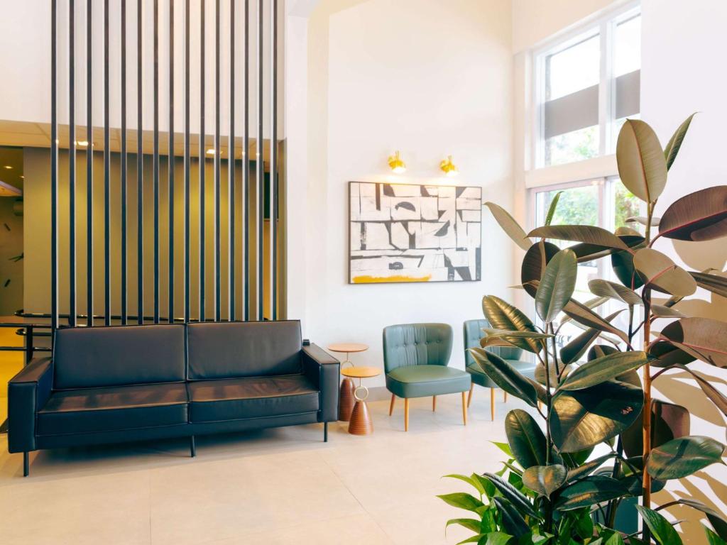 a living room with a couch and a plant at ibis Styles Goiania Marista in Goiânia