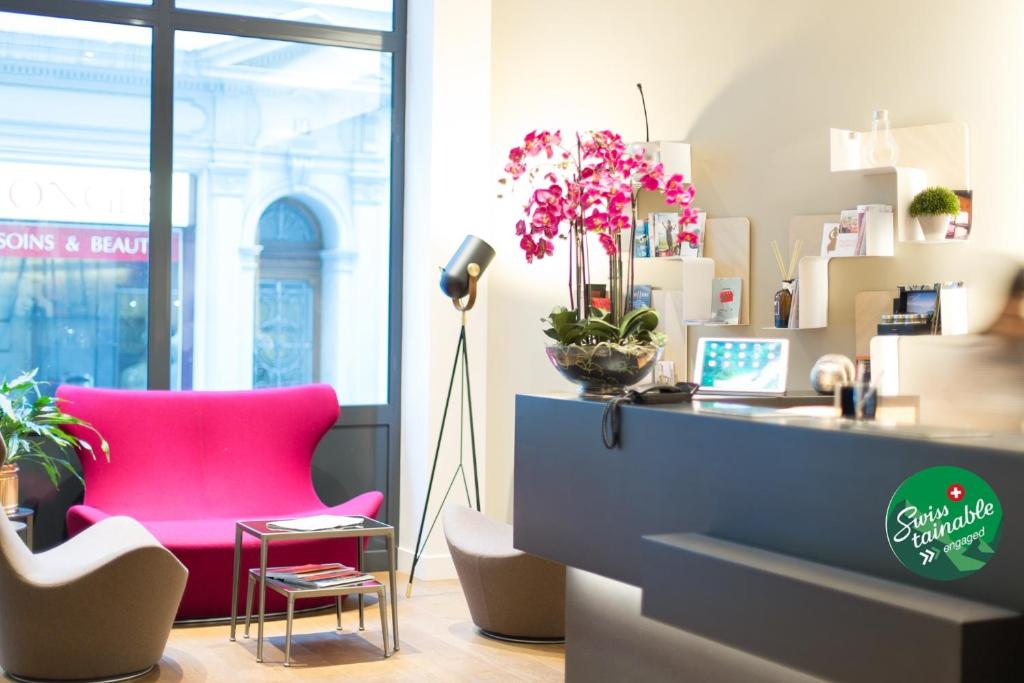 ein Büro mit einem rosa Stuhl und einem Schreibtisch in der Unterkunft Hôtel des Voyageurs Boutique in Lausanne