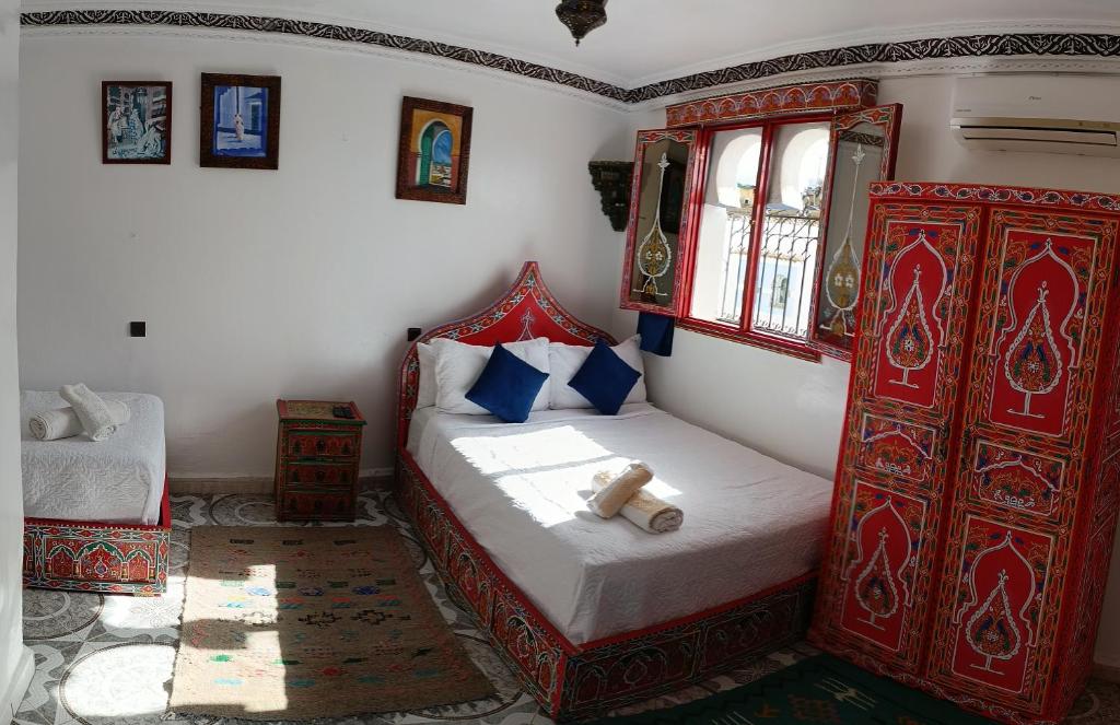 Un pat sau paturi într-o cameră la Hotel Chefchaouen