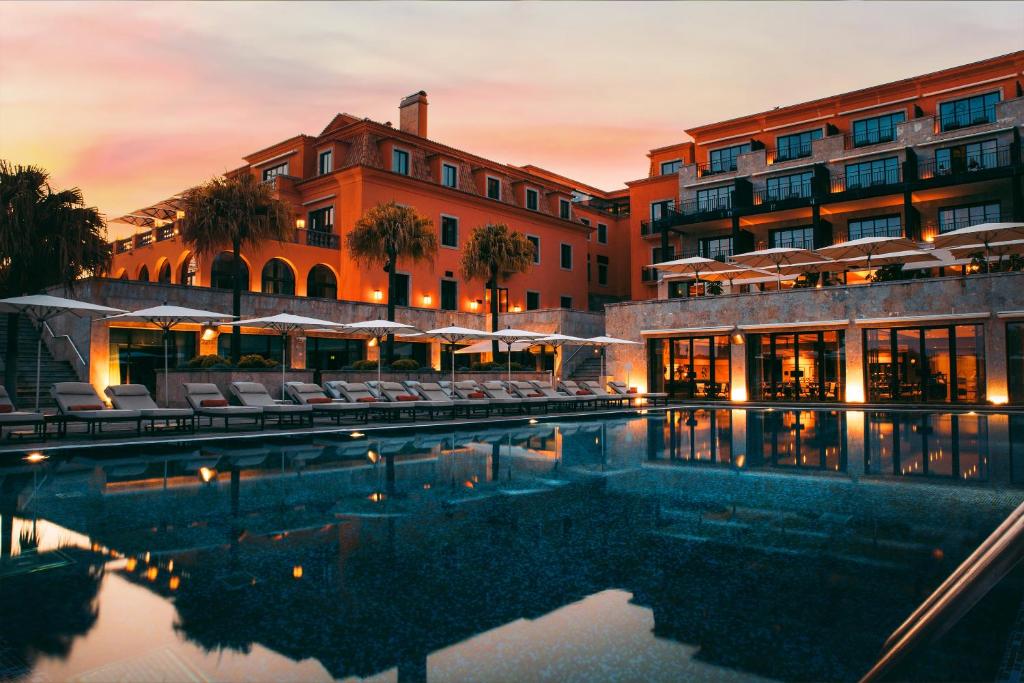 un hotel con piscina di fronte a un edificio di Grande Real Villa Itália Hotel & Spa a Cascais