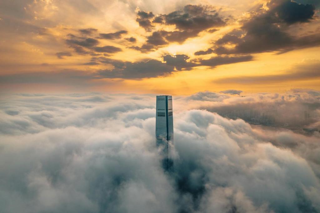 een wolkenkrabber midden in een zee van wolken bij The Ritz-Carlton, Hong Kong in Hong Kong