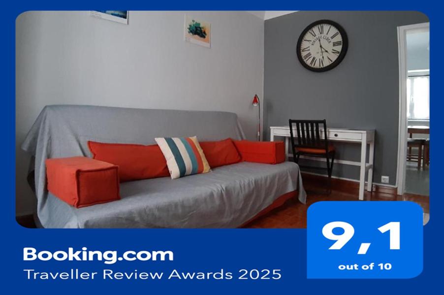 a living room with a couch and a clock on the wall at A Casa do Mestre in Évora