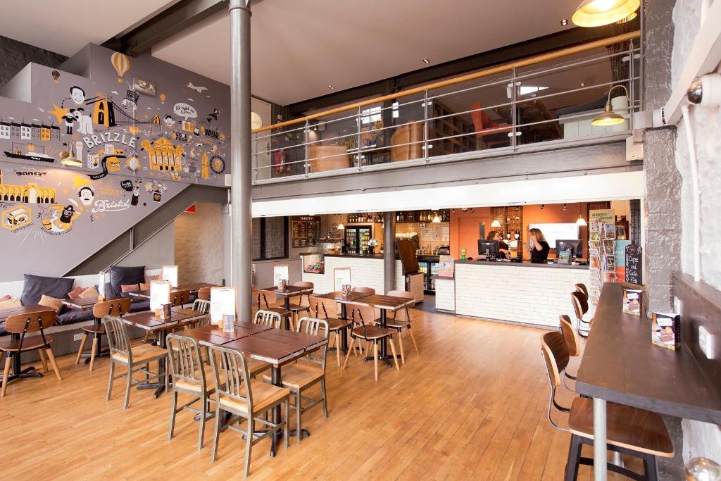 a restaurant with wooden tables and chairs and a bar at YHA Bristol in Bristol