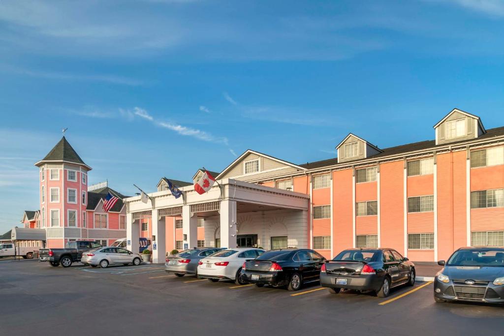 un grande edificio con auto parcheggiate in un parcheggio di Best Western Greenfield Inn ad Allen Park