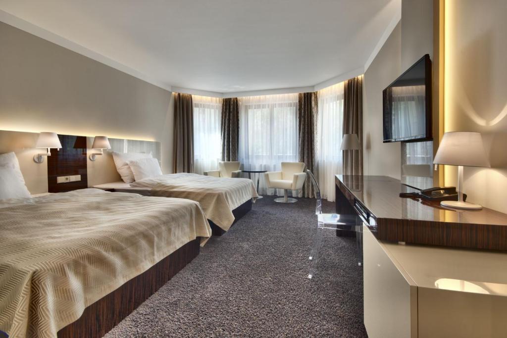 A bed or beds in a room at Prezident Luxury Spa & Wellness Hotel