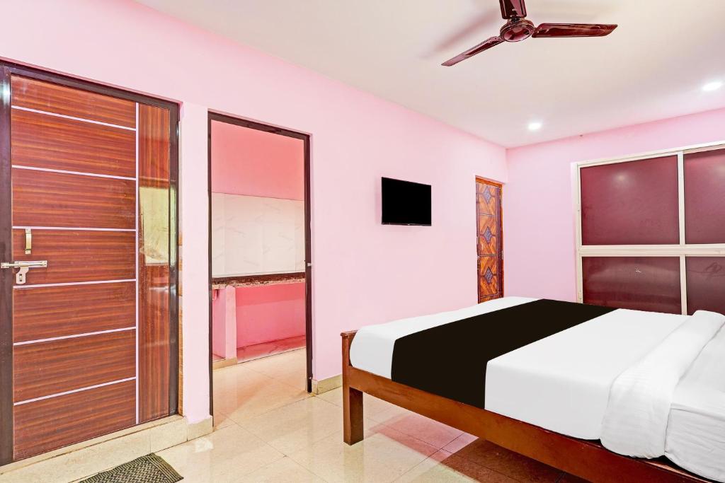 una camera con letto e porta scorrevole in vetro di Super Hotel O Daba Gardens Near Dolphin Junction a Alipur