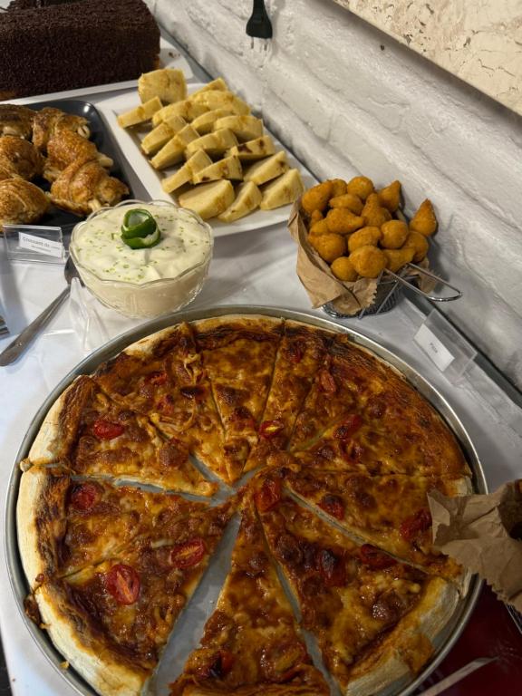 een pizza bovenop een tafel met ander voedsel bij Pousada Vila Italia - Porto da Dunas in Aquiraz