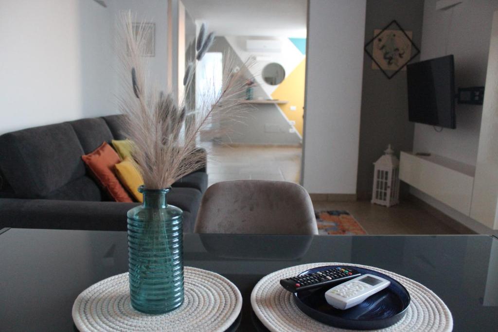 a living room with a vase and remote controls on a table at Casa Giuliani in Porto Cesareo