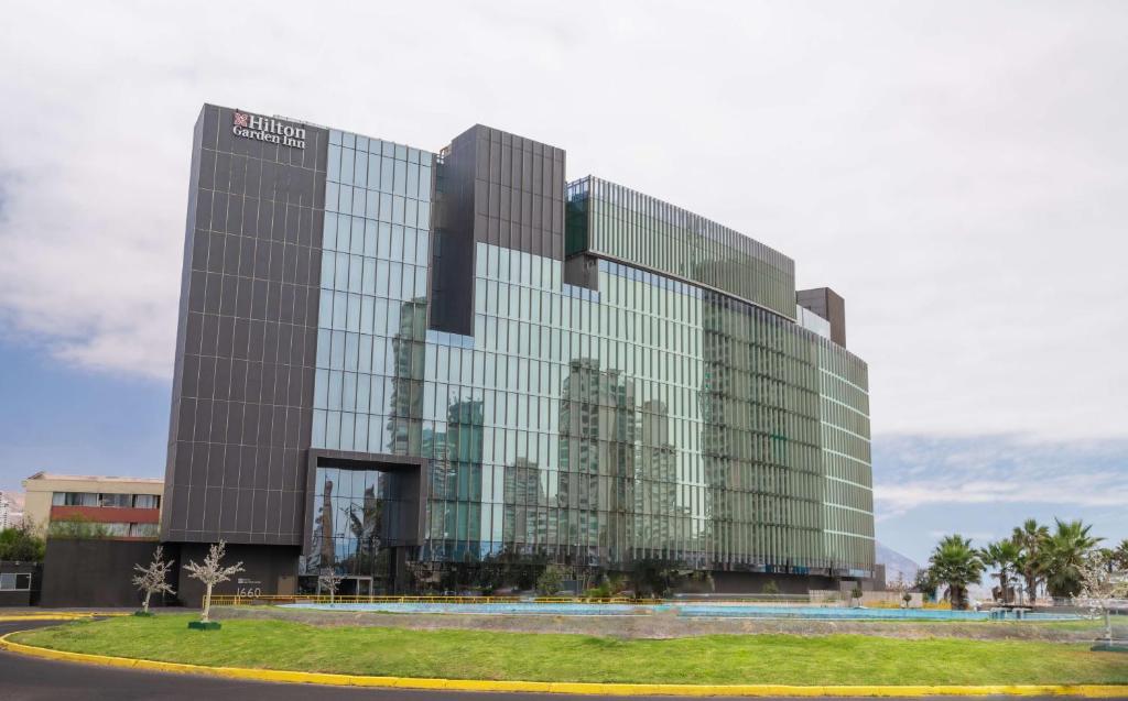 a glass office building with a lot of windows at Hilton Garden Inn Iquique in Iquique