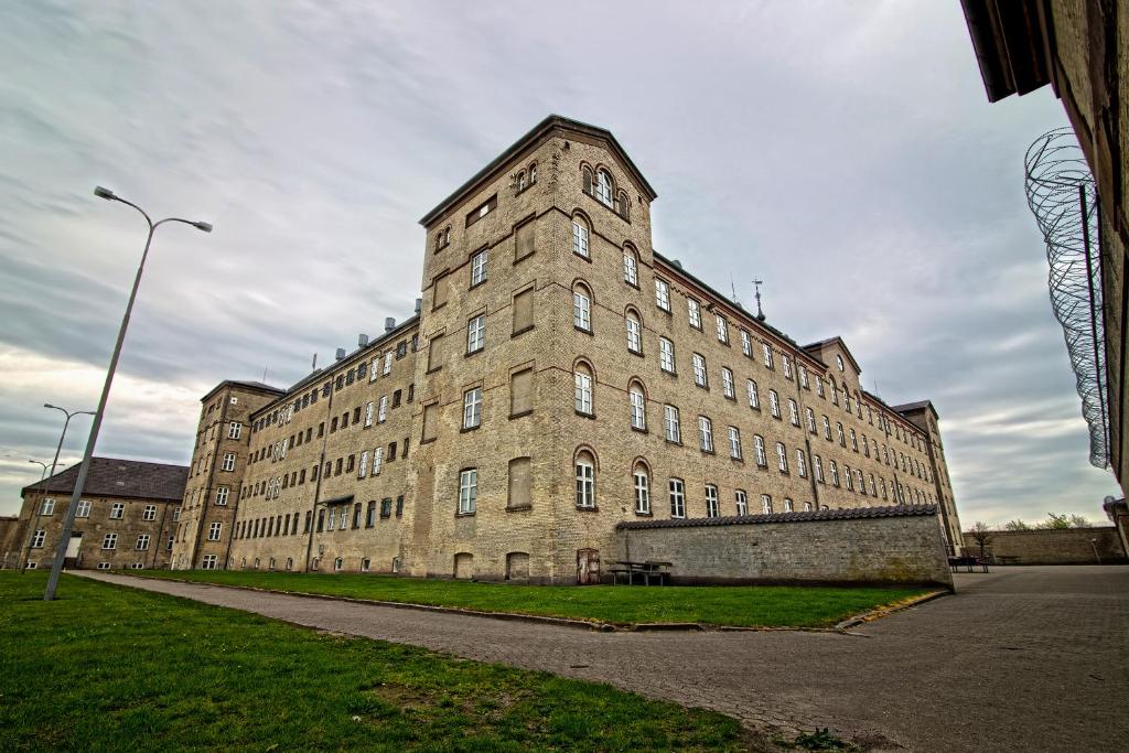 un grande edificio in mattoni con un lampione davanti di SleepIn FÆNGSLET a Horsens