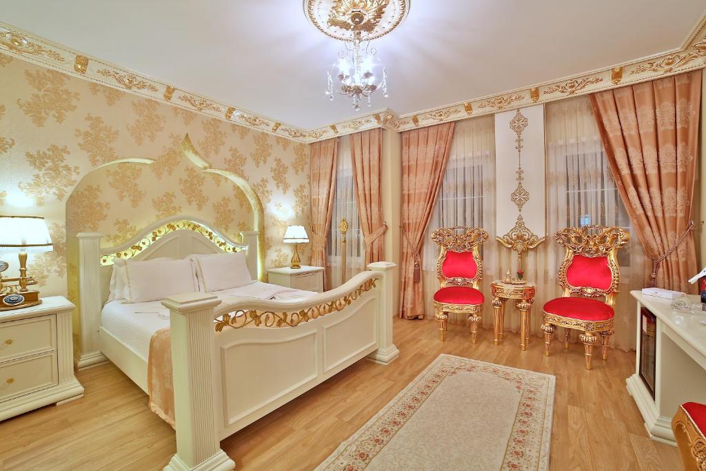 a bedroom with a bed and two red chairs at White House Hotel Istanbul in Istanbul