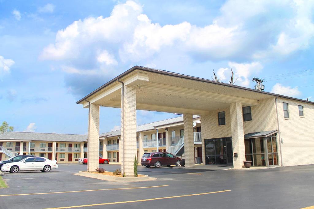 un gran edificio con un estacionamiento delante de él en American Inn - Paducah, en Paducah