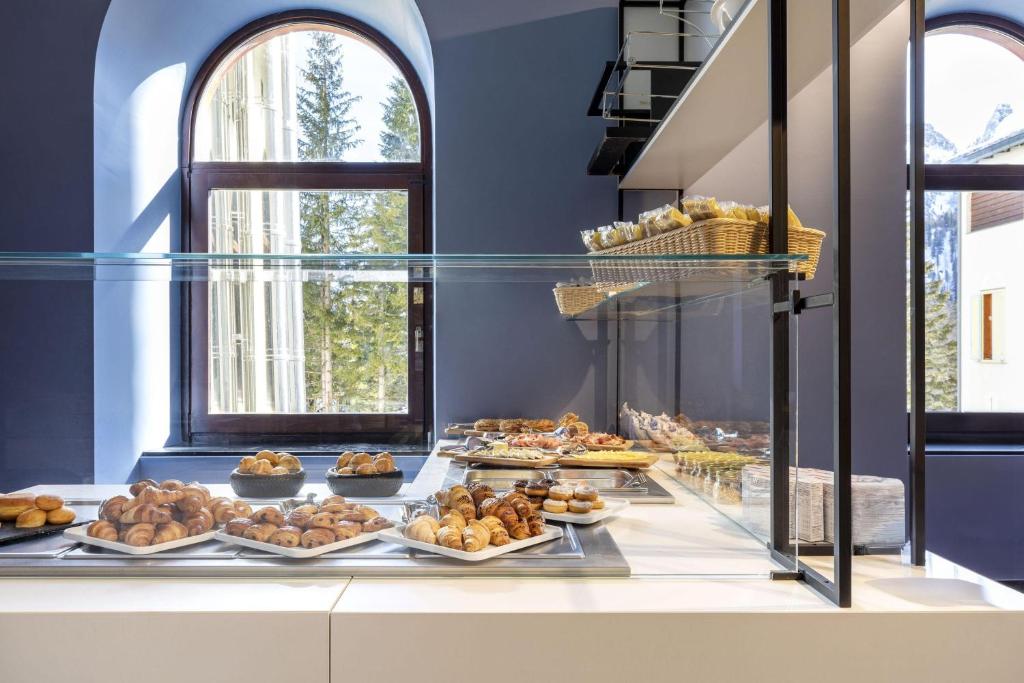 a bakery with many different types of pastries on display at B&B Hotel Passo Tre Croci Cortina in Cortina dʼAmpezzo