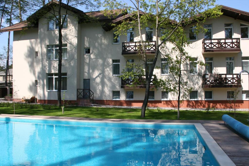 um edifício com piscina em frente a um edifício em Viktoria Park Hotel em Bucha