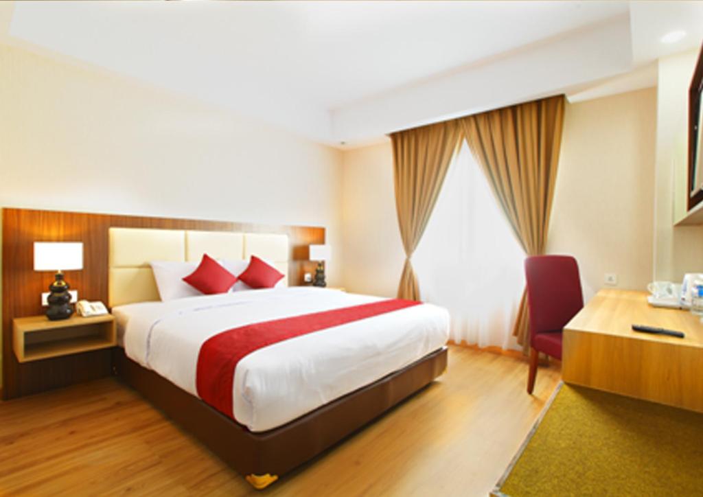 A bed or beds in a room at Orchardz Hotel Bandara