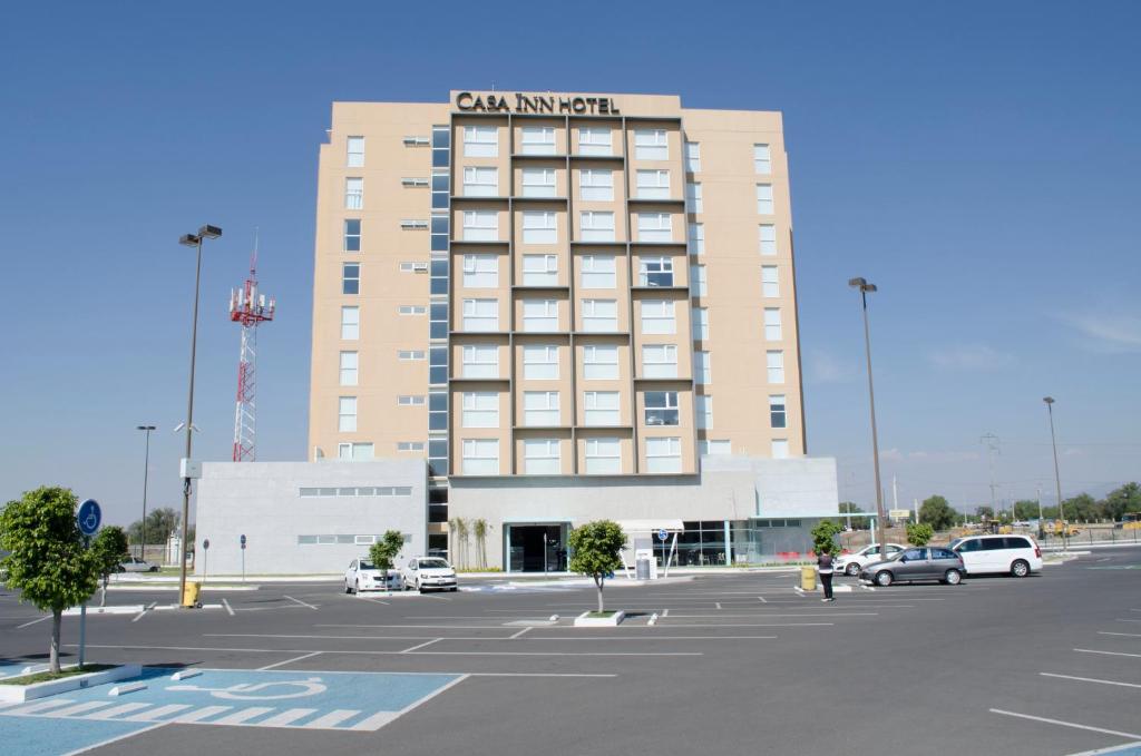 un edificio con un parcheggio di fronte di Casa Inn Galerias Celaya a Celaya