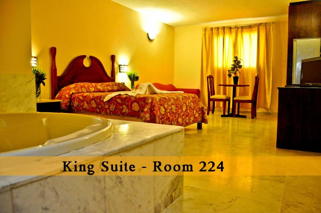 um quarto com uma suite king com uma cama e uma banheira em Hotel Marimba Punta Cana em Punta Cana