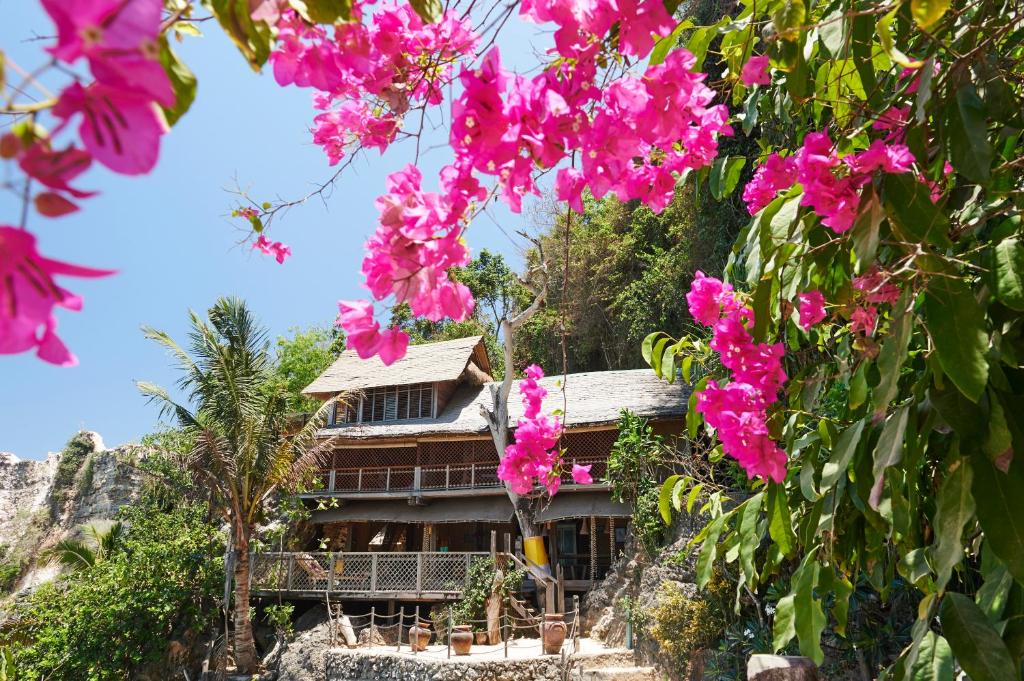 una casa su una collina con fiori rosa di The Island Houses Bingin a Uluwatu