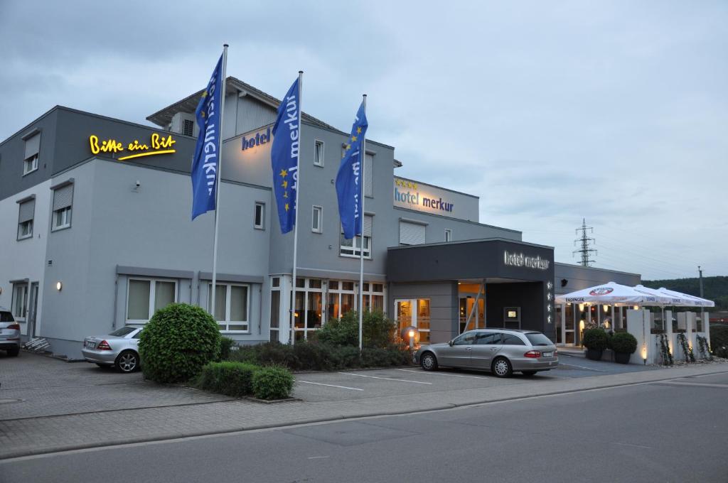 um hotel com carros estacionados em frente em Hotel Merkur em Landstuhl