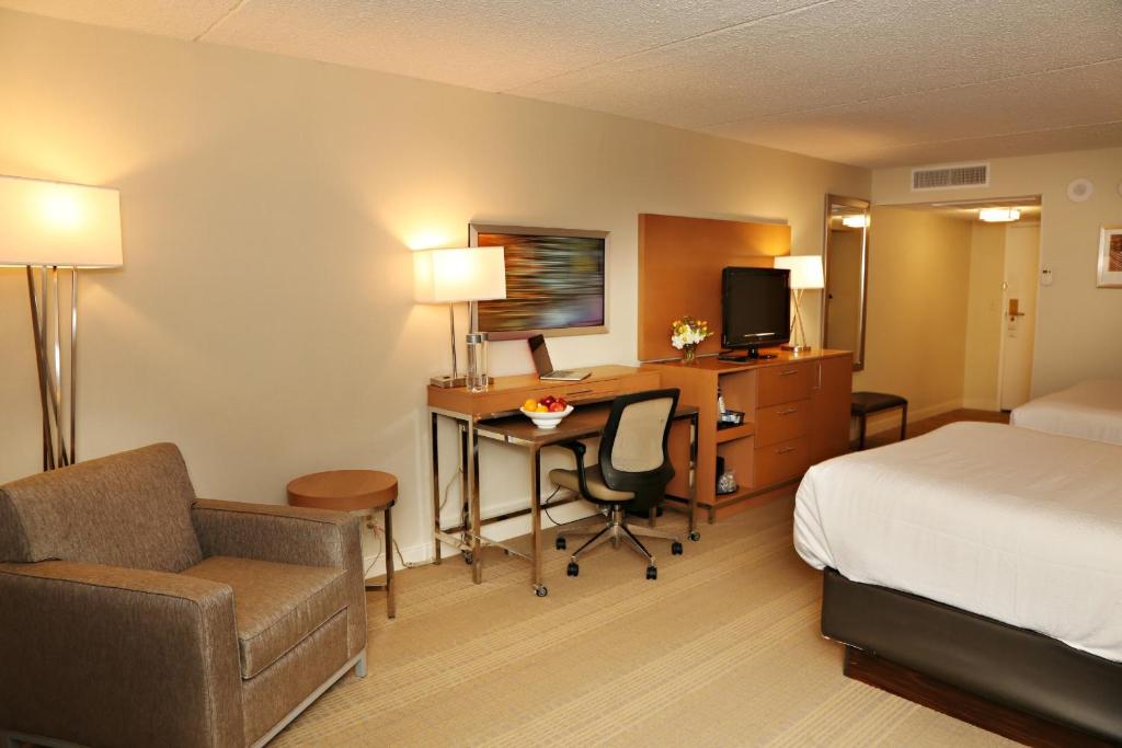 una camera d'albergo con letto, scrivania e letto e una camera con di enVision Hotel & Conference Center Mansfield-Foxboro a Mansfield