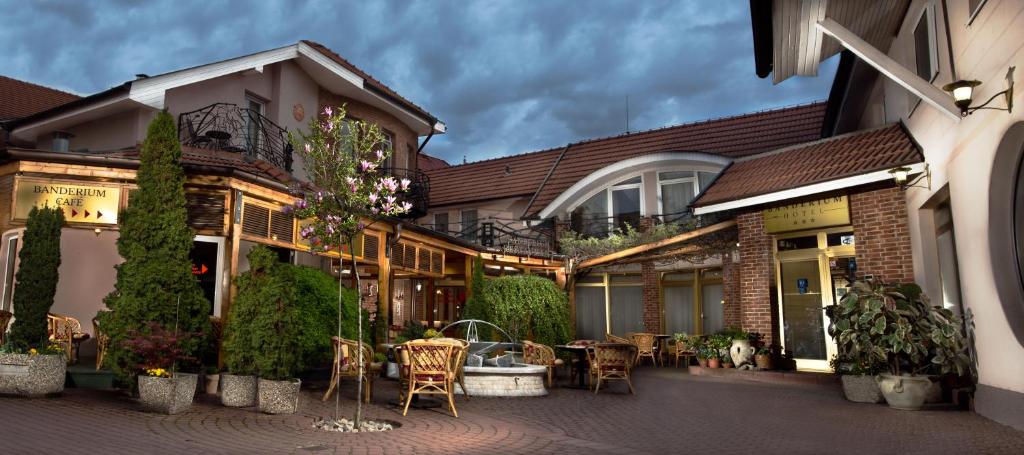 een gebouw met een patio met tafels en stoelen bij Hotel Banderium in Komárno