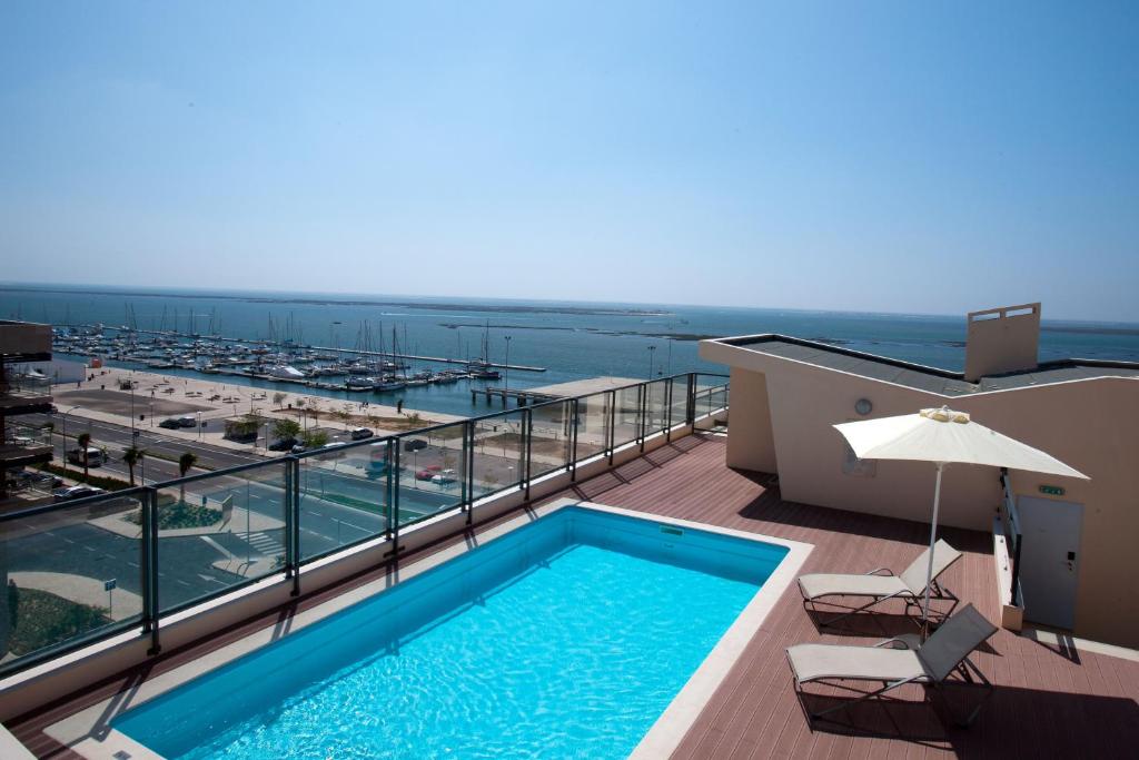 una piscina en un balcón con vistas al océano en Real Marina Residence, en Olhão