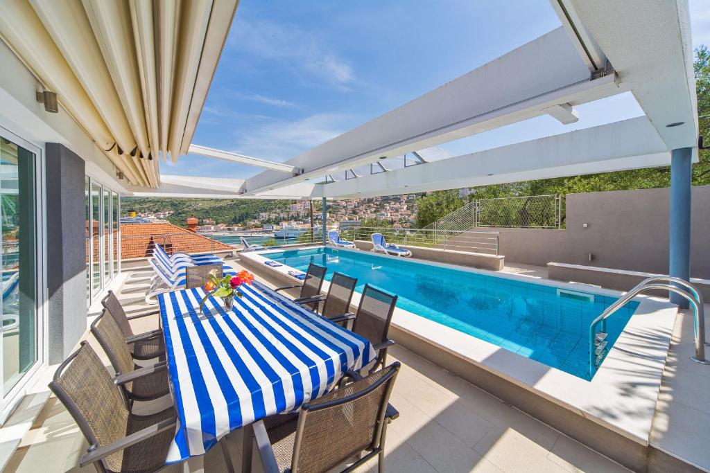 eine Terrasse mit einem Tisch und Stühlen neben einem Pool in der Unterkunft Villa Ancora in Dubrovnik